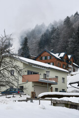 A house or cottage covered in snow in winter