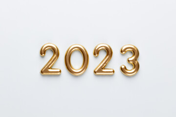 New year 2023 number, golden digits and santa hat over blue background.