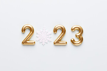 New year 2023 number, golden digits and santa hat over blue background.