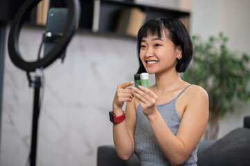 Smiling vlogger demonstrating new cosmetics to her online audience