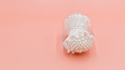 Cotton buds in box on a white background, Top view flat lay swabs cotton buds on orange background with copy space.