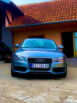 Vertical shot of a silver Audi S4 car on a porch