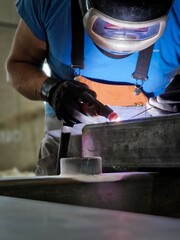 Vertical shot of a man during the welding process in his workshop