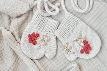 Fototapeta na wymiar Knitted mittens with embroidery. Kids clothes and accessories. Needlework and knitting. Hobbies and creativity. Knit for children. Handmade