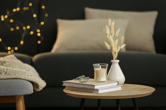 Side Table With Books And Decor Near Sofa In Room