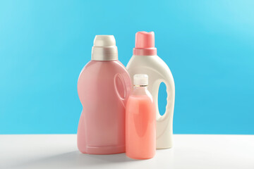 Bottles of laundry detergents on white table