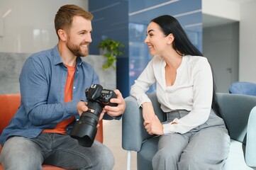 Photographer in office shows photo model in camera. Consultant adjusts activities company as whole....
