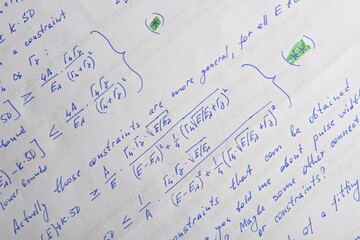Paper with written mathematical calculations as background, closeup