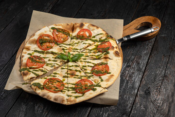 delicious pizza with cheese, greens, sauce in a restaurant
