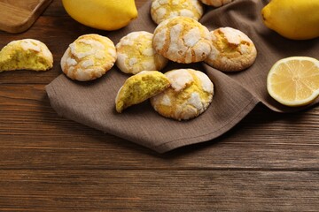 Delicious lemon cookies and citrus fruits on wooden table. Space for text