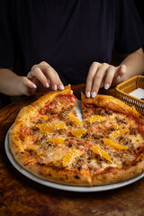 delicious pizza with cheese, greens, sauce in a restaurant

