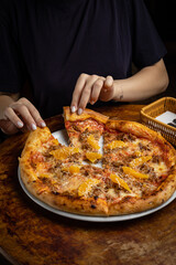 delicious pizza with cheese, greens, sauce in a restaurant
