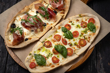 delicious pizza with cheese, greens, sauce in a restaurant
