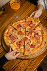 delicious pizza with cheese, greens, sauce in a restaurant
