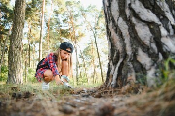 Image of cute kid with magnifying glass exploring the nature outdoors. Adorable little girl playing in the forest with magnifying glass. Curious child looking through magnifier on a sunny day in park.