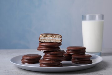 Tasty choco pies and milk on grey table