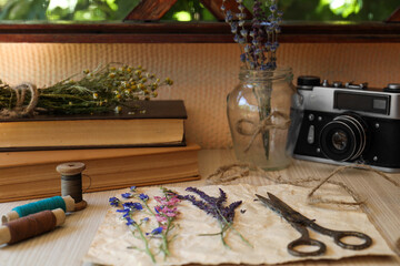 Composition with beautiful dried flowers and paper on wooden table