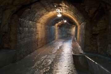 Humid tunnel with lights turned on connected to the Zerostrasse under the Pula Castle Kastel