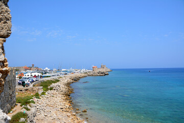 Fototapeta na wymiar greek coastline with boats and windmills and blue sea and sky