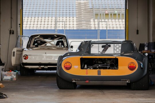 Garage with white and yellow vintage sportscars ready to race in the Assen TT Circuit, Netherlands