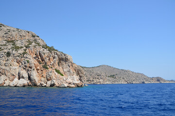 island with rocky hills, clear sky and blue sea, close-up