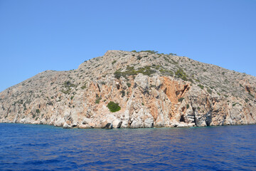 Fototapeta na wymiar rocky island isolated with blue sky on horizon and blue sea