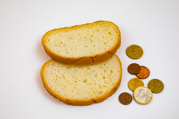 Two slices of bread and euro coins on a white background