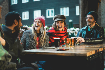 Young people having fun drinking beer at pub restaurant - Soft focus on left girl face