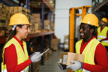 Happy multiracial workers having fun inside warehouse - Focus on woman hardhat