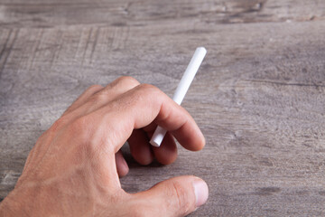 young guy holding a cigarette