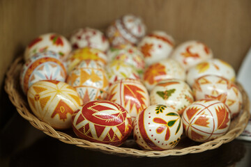 Colorful hand painted Easter Eggs in a wicker bowl. Egg decorating in Slavic culture.
