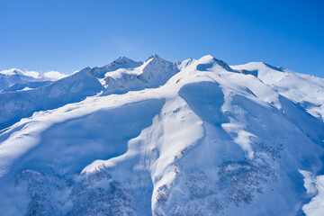 Fototapeta na wymiar Aerial view of snowy mountains on a sunny day