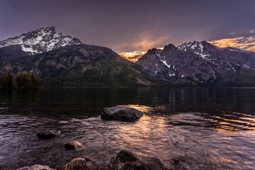 Sunset view with a purple sky behind snowy mountains and lake reflecting, Grand Teton national park