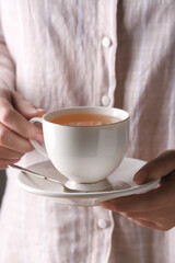 Woman holding cup of tasty tea, closeup