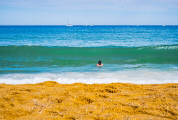 Obraz premium Caucasian boy swim in the sea, Barcelona city