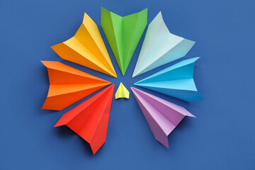Colorful paper planes on blue background