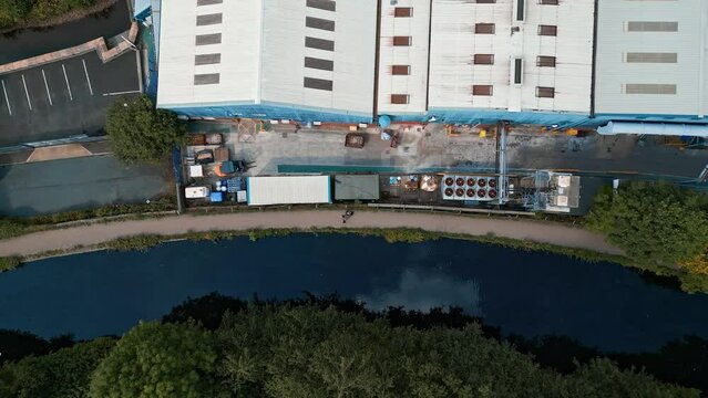 Overhead aerial footage of factory roof tops showing industrial steel site with roads paths and textures.