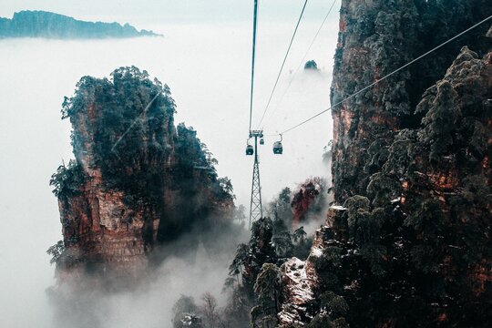 Tianmenshan Cableway View With Cottages Going And Coming Through Foggy, Forested Mountains