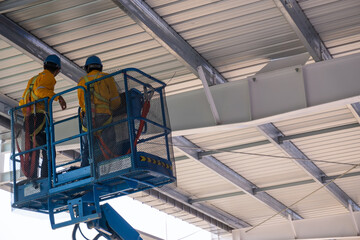 Engineers inspects steel structure by boomlift at site construction