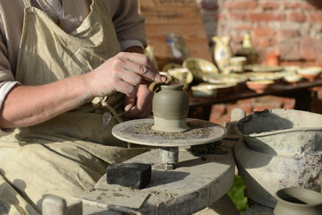 Fototapeta na wymiar Tornio, Artigiano ceramista lavora un vaso di argilla