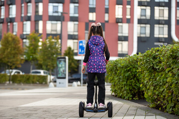 Little Girl Riding Segway Having Fun Spending Weekend.