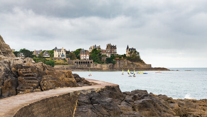 The promenade of Dinard, Brittany, France, with blue rippled waters of atlantic ocean, on a rainy day. Traditional villas on the backgroud, with dramatic sky.