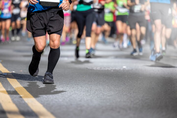 Shallow focus view of blurred urban Marathon runners legs on the street with copy spac