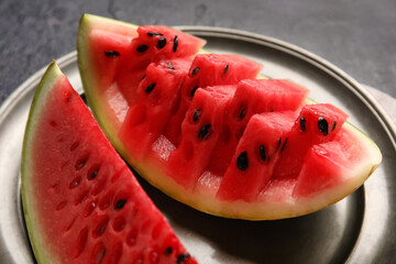 Plate with slices of watermelon on dark background, closeup