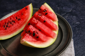 Plate with slices of watermelon on dark background, closeup