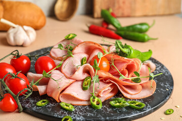 Board with slices of tasty ham, tomatoes, chili pepper and microgreen on table, closeup