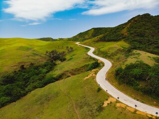 Landscape of a road through green hills in Batanes Island, Philippines.