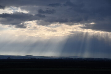 Sun rays from cloudy sky  over mountain