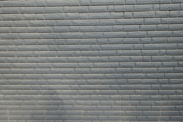 Surface of dusty black painted brick veneer wall