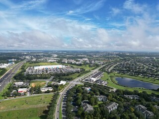 Bird's eye view of a lake surrounded by green trees near a highway in Clermont, Florida
